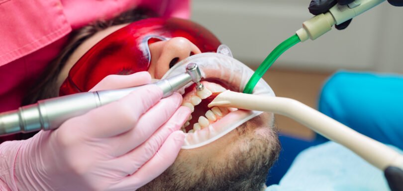 Professional teeth cleaning. Dentist cleans the teeth of a male